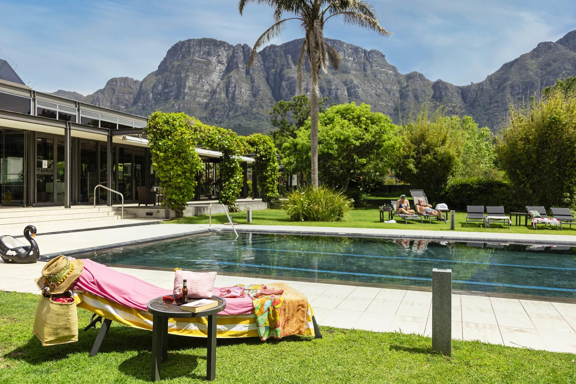 Pool, loungers and lawns at a Cape Town hotel beneath the mountains